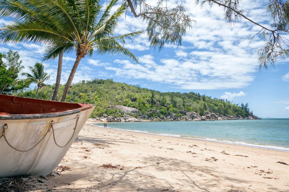 A serene beach on Magnetic Island with crystal-clear water and lush greenery